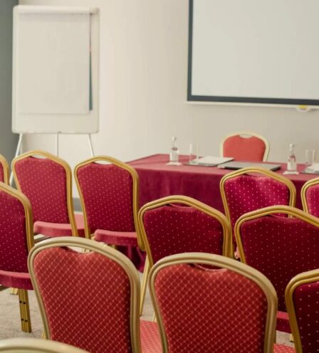Conference room at Scotts Hotel Killarney with red chairs and a presentation setup.