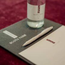Elegant conference setup at Scotts Hotel, Killarney with branded pen, notepad, and water bottle.