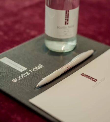 Elegant conference setup at Scotts Hotel, Killarney with branded pen, notepad, and water bottle.