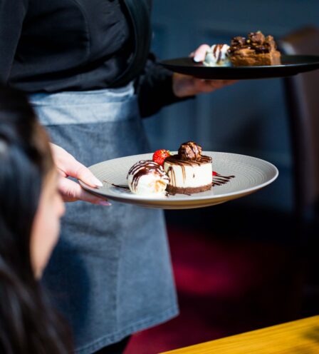 Server presenting chocolate desserts to a guest at Scotts Hotel Killarney restaurant.