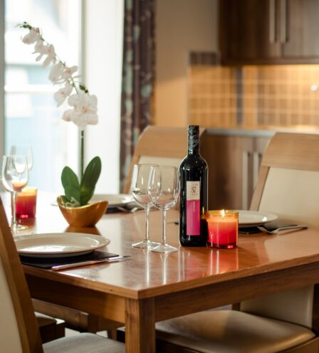 Elegant dining table set with wine, glasses, orchid, and candle at Scotts Hotel Killarney.