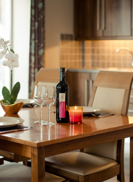 Elegant dining setup with wine, candles, and orchid in a cosy hotel room at Scotts Hotel Killarney.