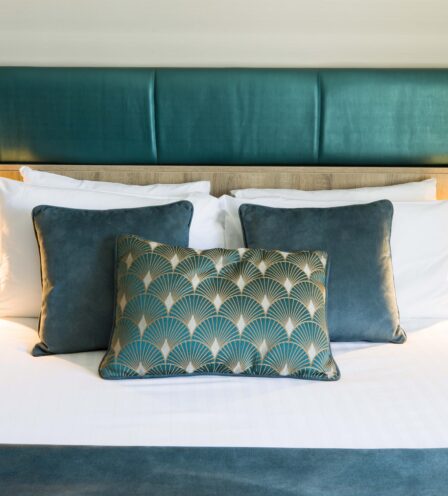 Elegant hotel room with a plush bed set and decorative pillows at Scotts Hotel Killarney.