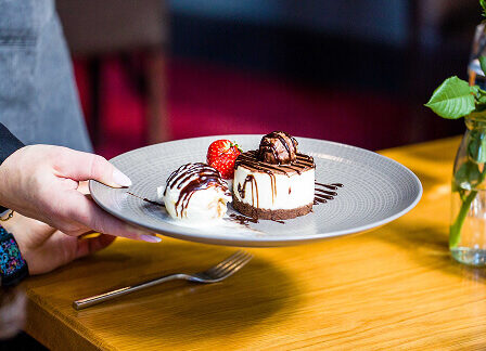 Elegant dessert at Scotts Hotel Killarney, served on a grey plate with chocolate drizzle.