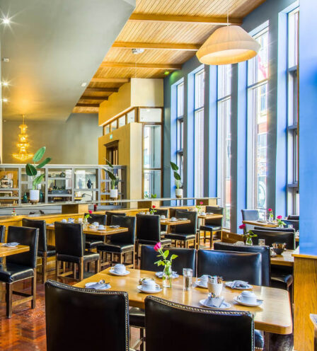 Elegant dining area in Scotts Hotel Killarney with large windows, cosy seating, and warm lighting.