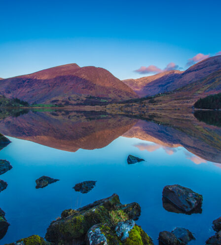Tranquil lake with vibrant mountain reflection at sunset near Scotts Hotel Killarney.