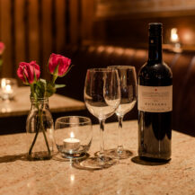 Romantic table setting with wine, flowers, and candle at Scotts Hotel Killarney restaurant.