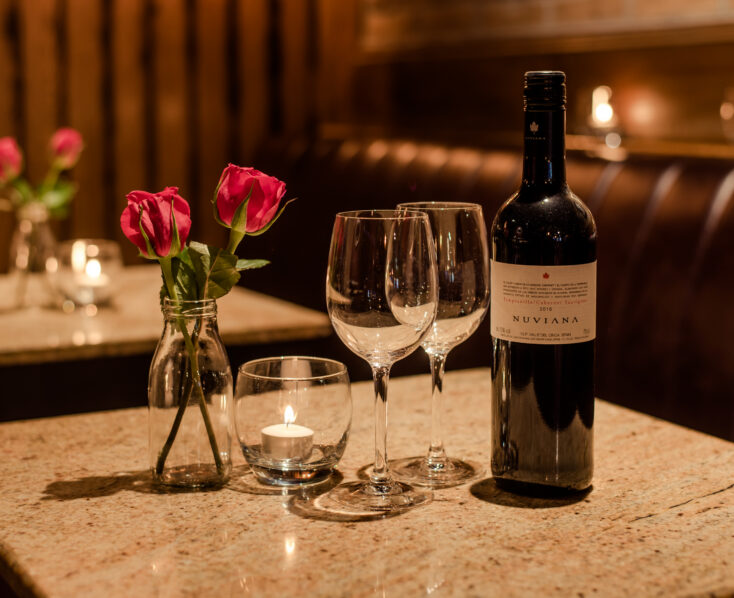 Romantic table setting with wine, flowers, and candle at Scotts Hotel Killarney restaurant.