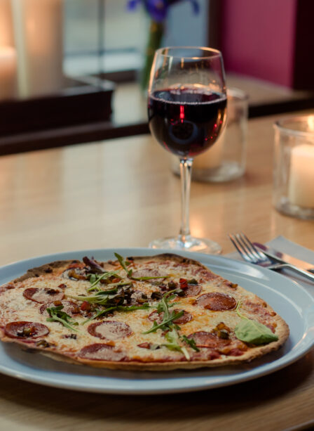A cosy table setting with a pizza, wine, and candles at Scotts Hotel Killarney.
