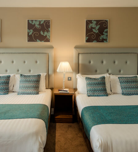 Elegant twin beds in a cosy room at Scotts Hotel Killarney with soft lighting and inviting decor.