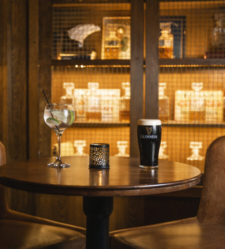 Cosy bar setting with drinks on a table at Scotts Hotel Killarney, featuring warm lighting.