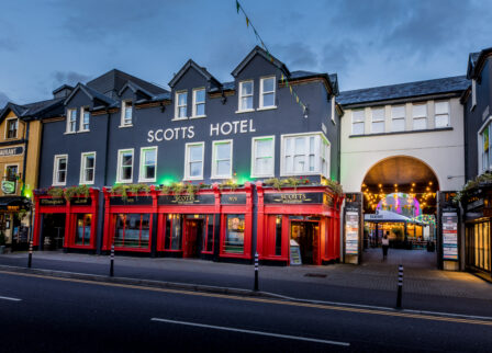 Charming facade of Scotts Hotel Killarney at dusk, warmly lit with inviting entrance.