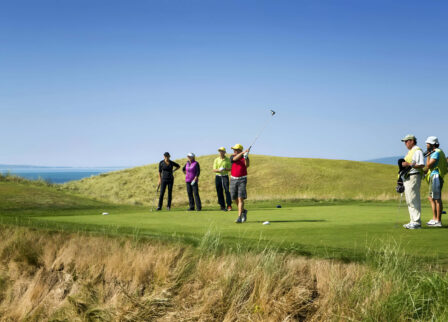 Golfers enjoying a sunny day on a scenic course at Scotts Hotel Killarney.