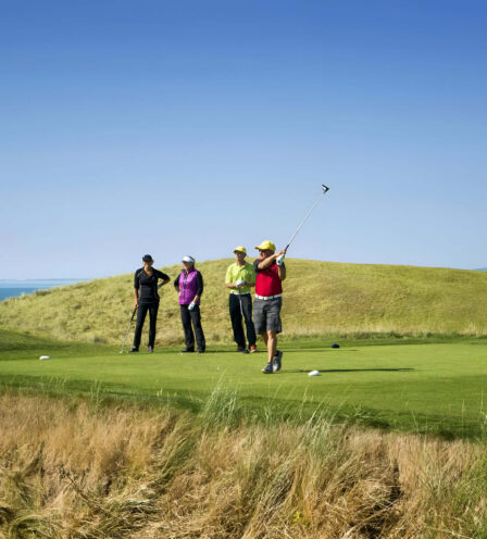 Golfers enjoying a sunny day on a scenic course at Scotts Hotel Killarney.