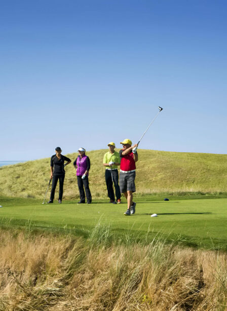Golfers enjoying a sunny day on a scenic course at Scotts Hotel Killarney.