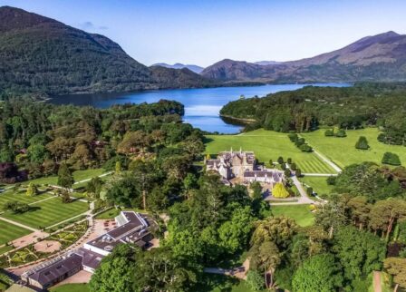 Aerial view of Scotts Hotel Killarney surrounded by lush greenery and scenic mountains.