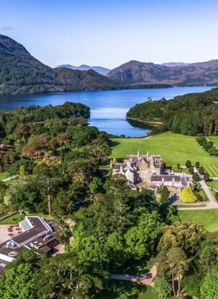 Aerial view of Scotts Hotel Killarney surrounded by lush greenery and scenic mountains.