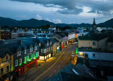Evening street view of Scotts Hotel Killarney, with people strolling under a dusky sky.
