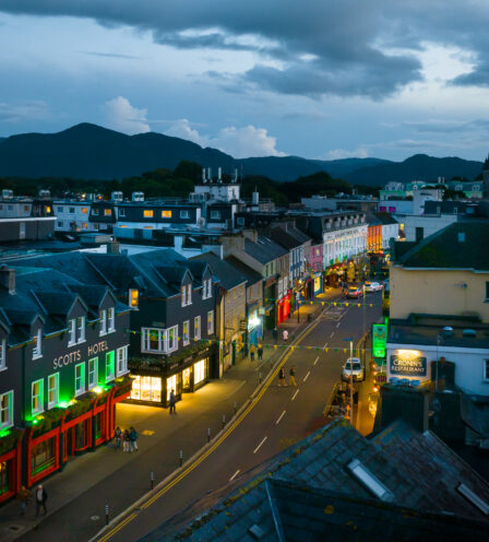 Evening street view of Scotts Hotel Killarney, with people strolling under a dusky sky.