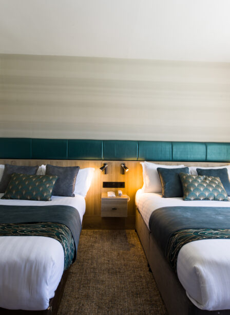 Elegant twin beds in a cosy hotel room at Scotts Hotel Killarney, featuring modern decor.
