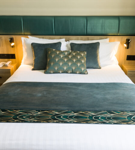 Elegant hotel room with plush bedding, warm lighting, and stylish decor at Scotts Hotel Killarney.