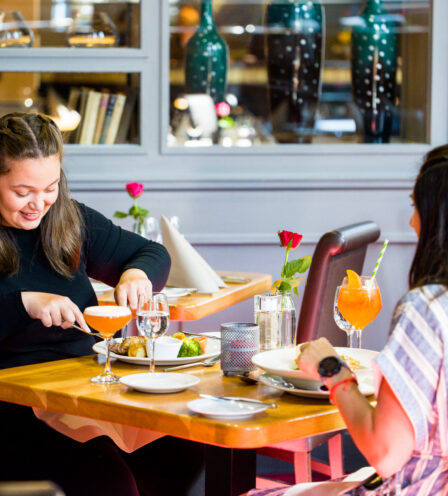 Two women enjoy a meal and drinks at Scotts Hotel Killarney's cosy restaurant.