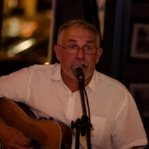 Musician performs live with a guitar at Scotts Hotel Killarney, creating a warm ambience.