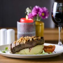 Elegant steak dish with mashed potatoes, paired with a glass of red wine at Scotts Hotel Killarney.
