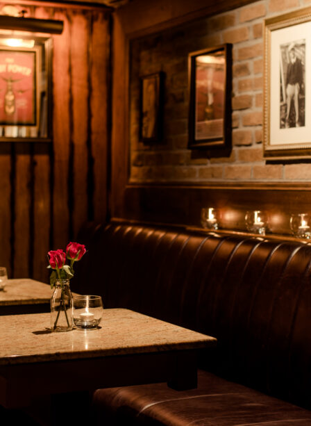 Cosy dining area with red roses at Scotts Hotel Killarney, warm lighting and framed art on walls.