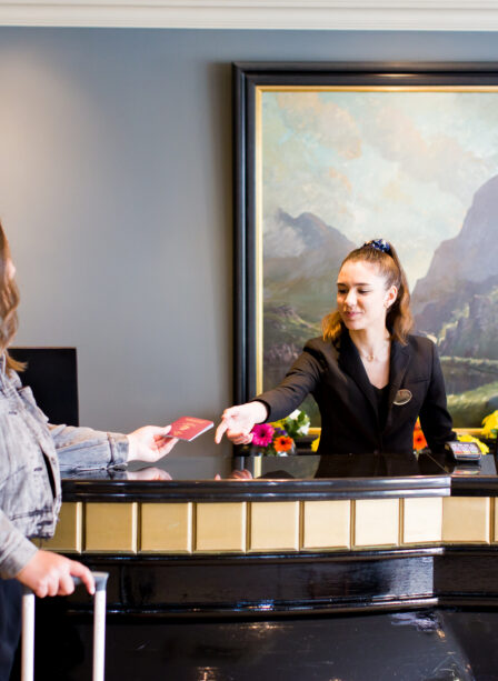 Guest checking in at Scotts Hotel reception with a friendly staff member.