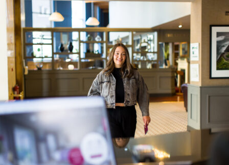 Woman smiling in the bright, welcoming lobby of Scotts Hotel Killarney.