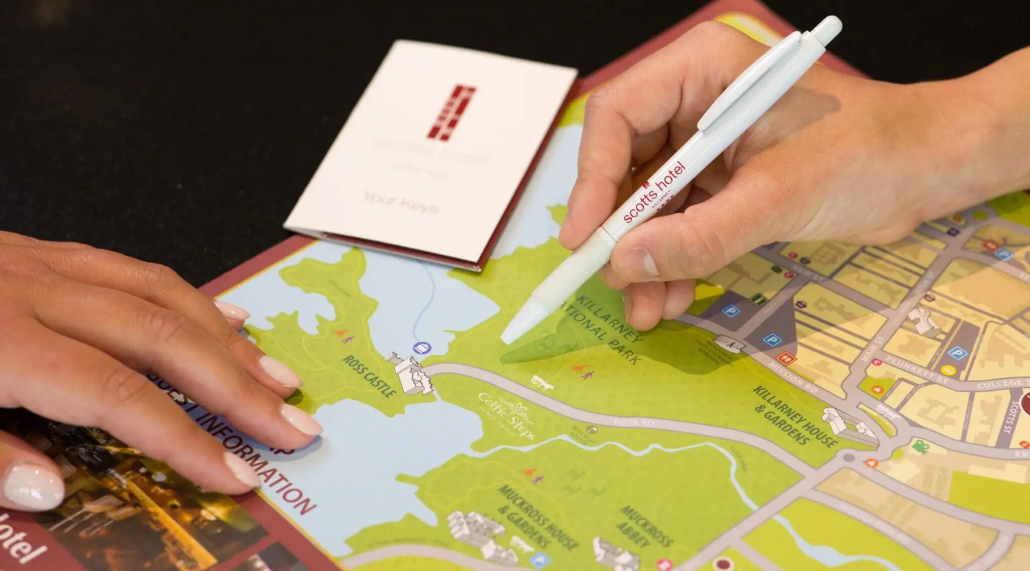 Hotel guests explore Killarney map with Scotts Hotel pen.