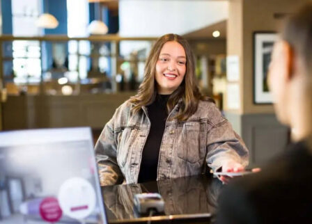 Woman smiling at the reception desk of Scotts Hotel Killarney.