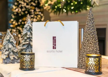 Festive table setting at Scotts Hotel Killarney with decorative trees and gift bag.