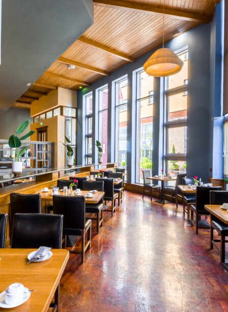 Elegant dining area with wooden tables, leather chairs, and large windows at Scotts Hotel Killarney.