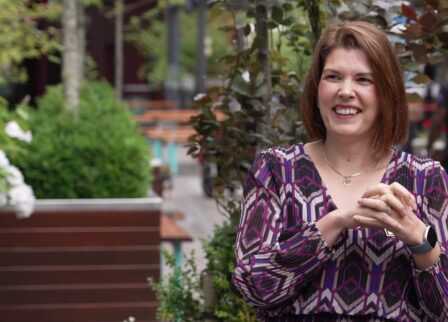 Smiling woman enjoying a sunny day in Scotts Hotel Killarney's lush garden terrace.