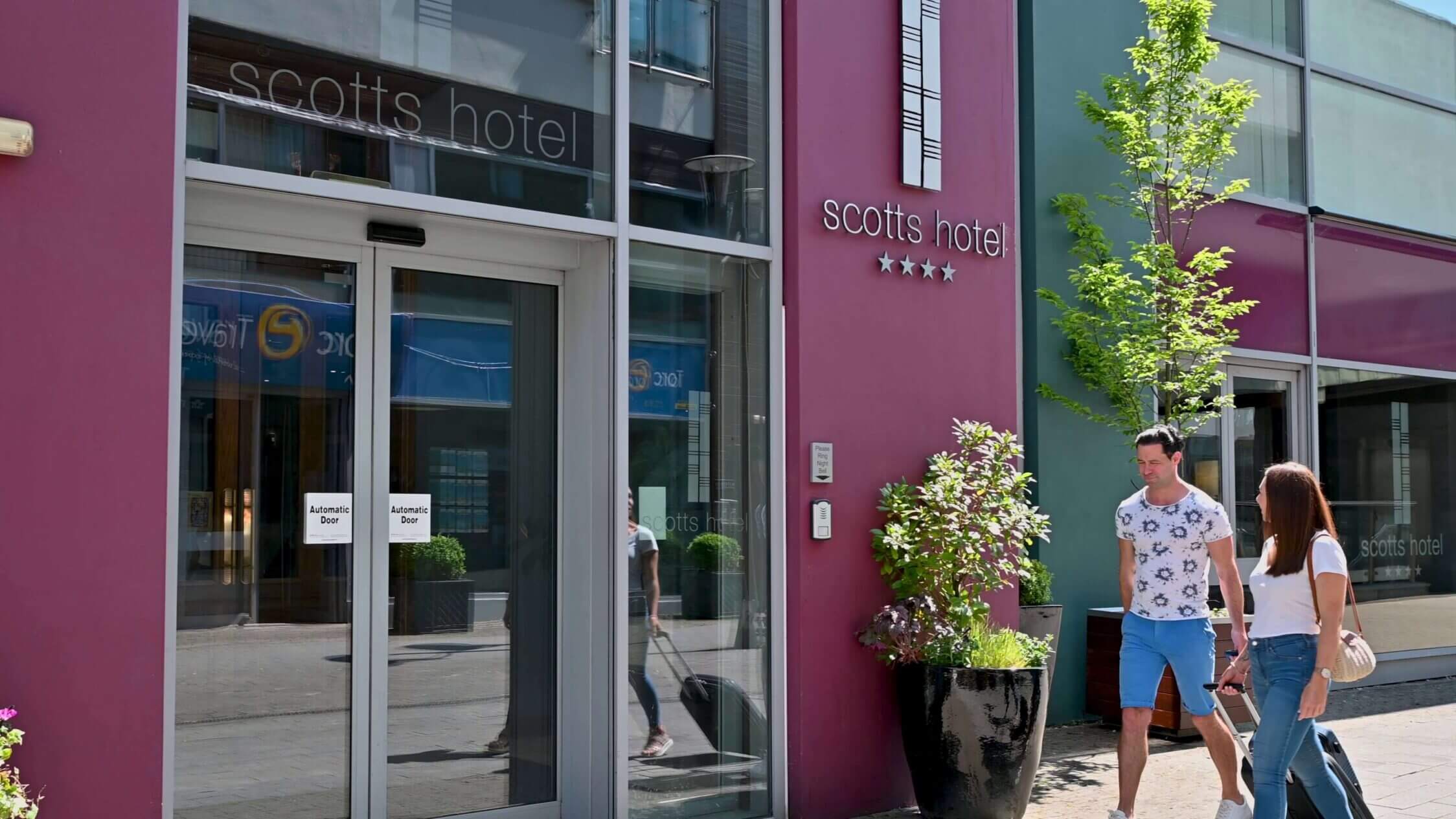 Guests walking past the entrance of Scotts Hotel Killarney on a sunny day.