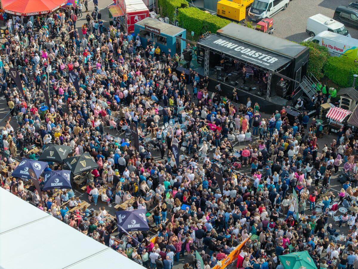 A lively outdoor festival at the Glenagle Hotel Killarney with a large crowd enjoying music and food.