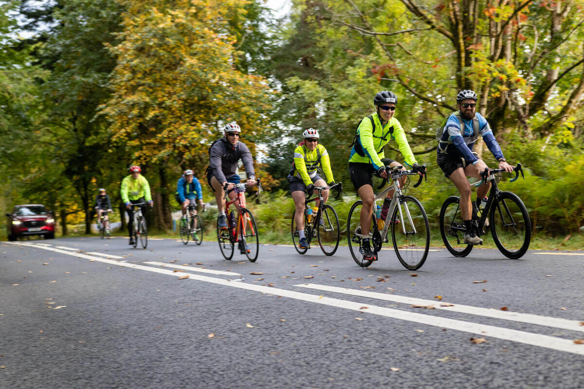 Cyclists enjoy a scenic ride near Killarney amidst vibrant autumn foliage.