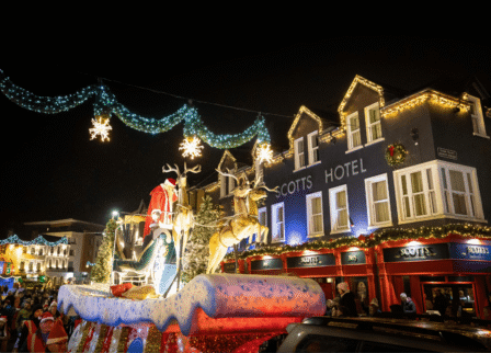 Festive evening at Scotts Hotel Killarney with Christmas lights and joyful crowd.